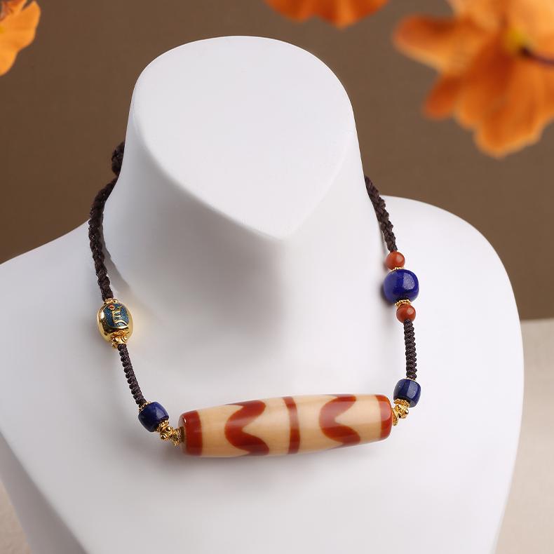 Tibetan handcrafted red carnelian agate tooth bead amulet pendant, inspired by Buddhist jewelry art.