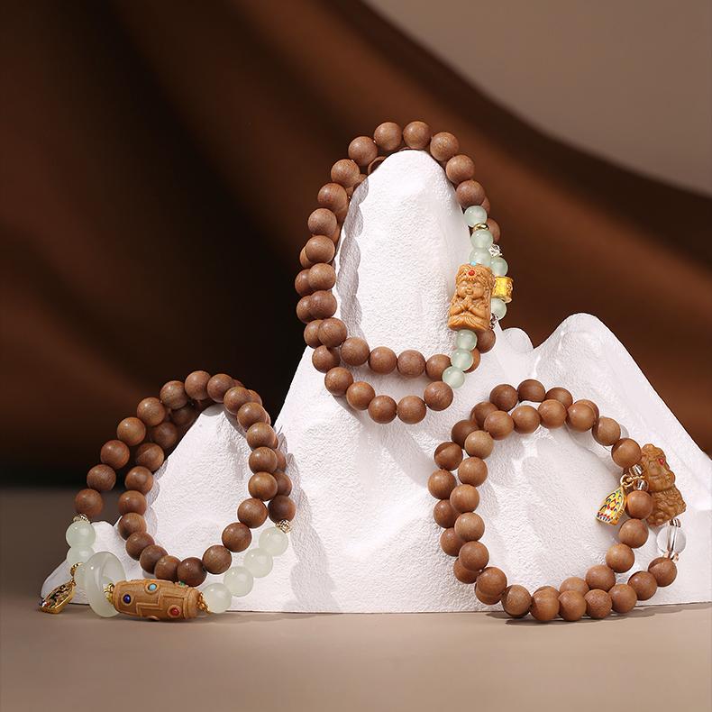 Spiritual sandalwood bracelet featuring Nine-Eye Dzi charm and glass round beads, inspired by Tibetan sacred art