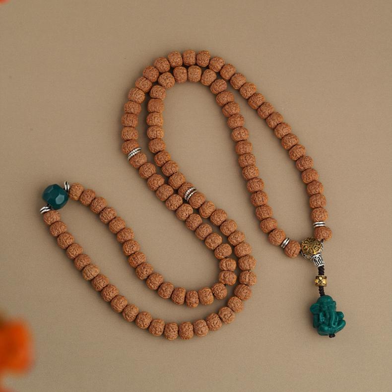 Handcrafted Bodhi and glass Tibetan jewelry piece with copper connectors.