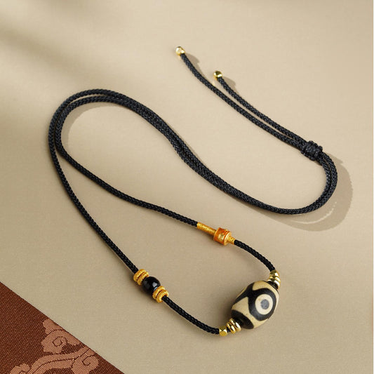 Handcrafted Tibetan Agate Dzi Bead Pendant featuring three eyes, representing wealth and spiritual clarity