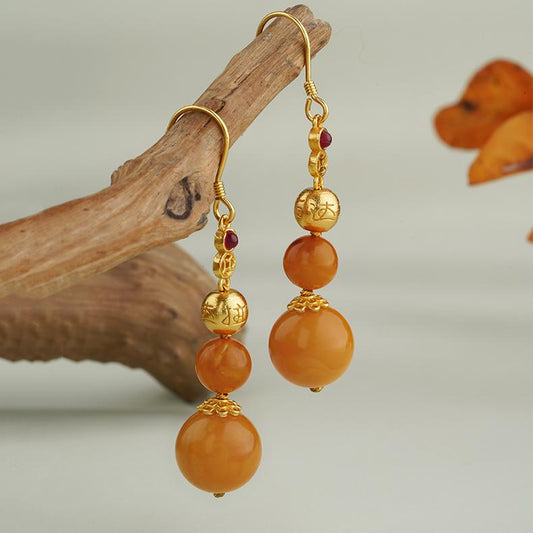 "Tibetan Buddhist-inspired amber earrings with 925 silver and zircon, symbolizing spiritual harmony."