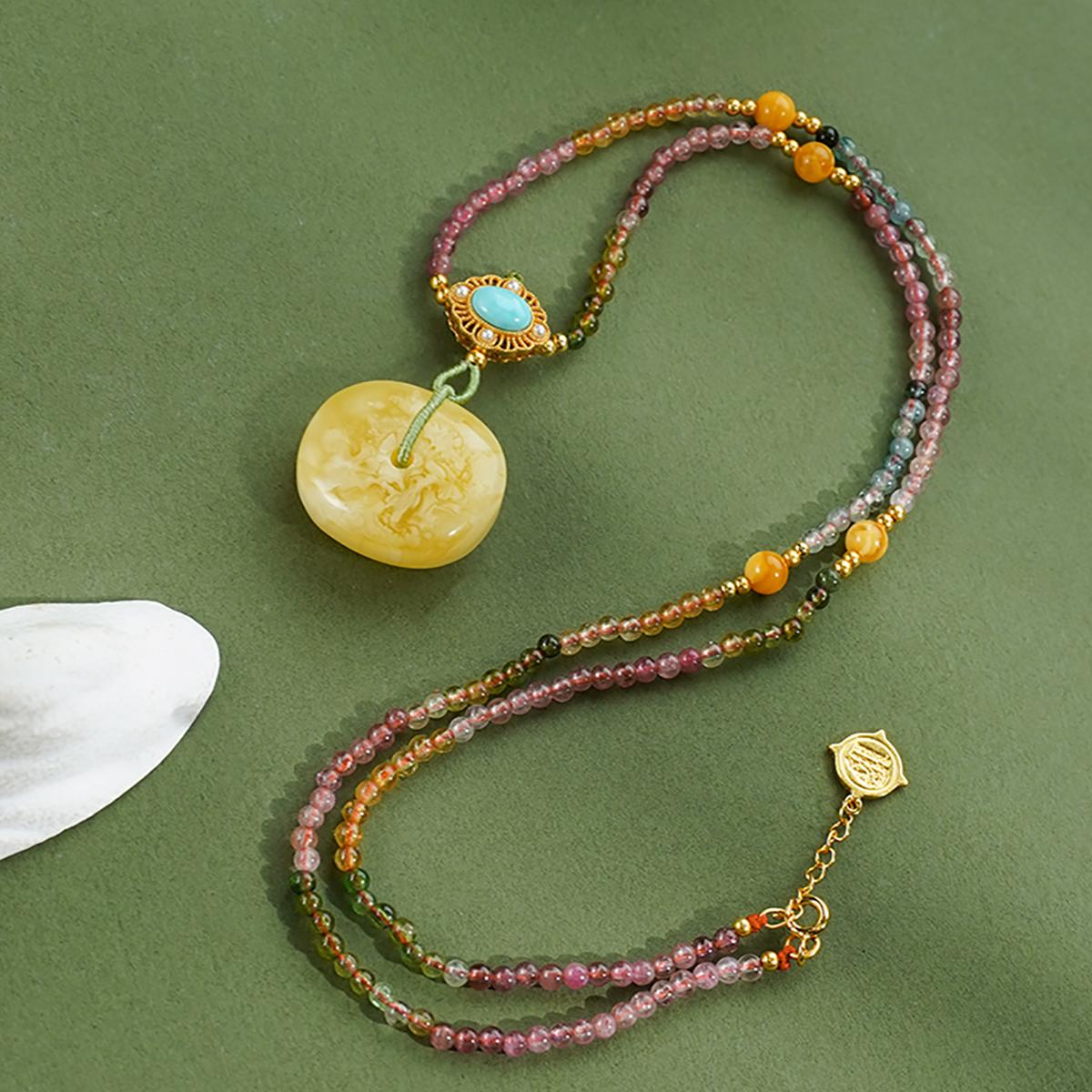 Spiritual Tibetan pendant made from amber, turquoise, and tourmaline — a symbol of blessings and joy.