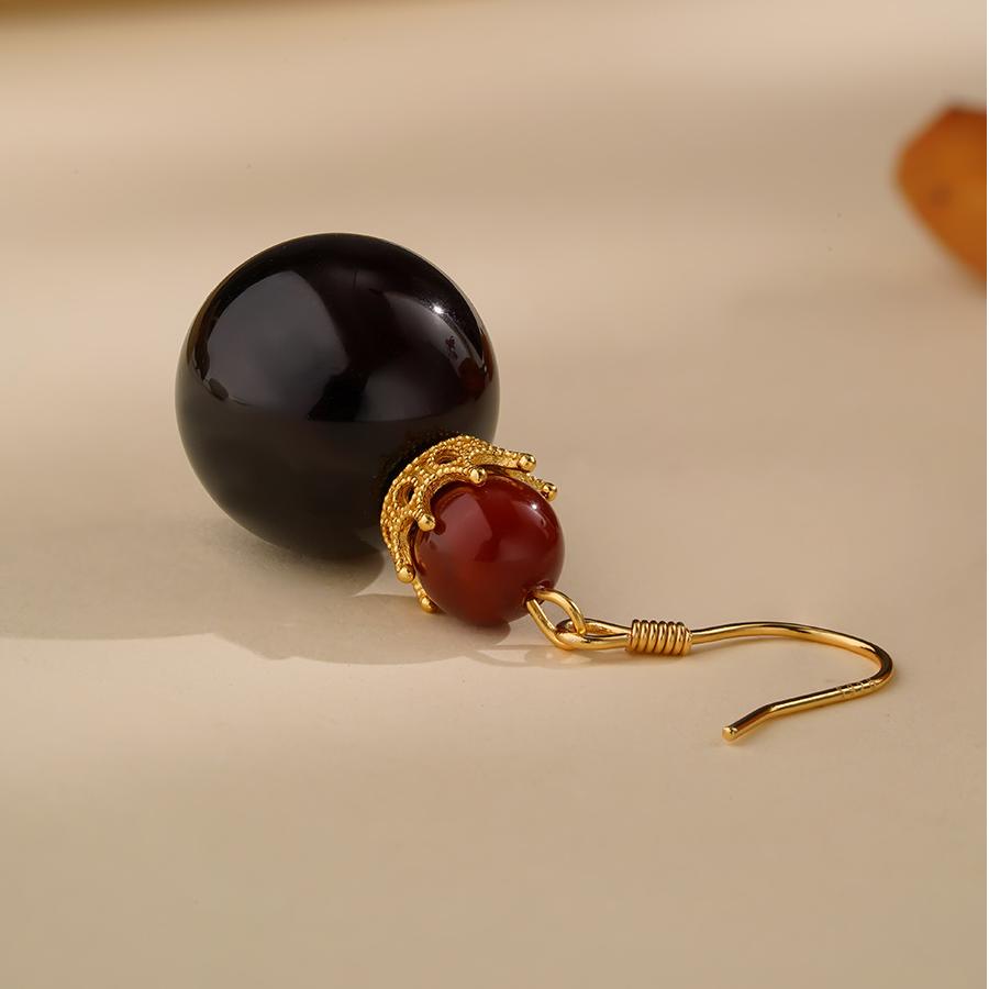 "Elegant handmade blood amber and agate earrings in 925 silver, symbolizing the balance of life force and spiritual protection."