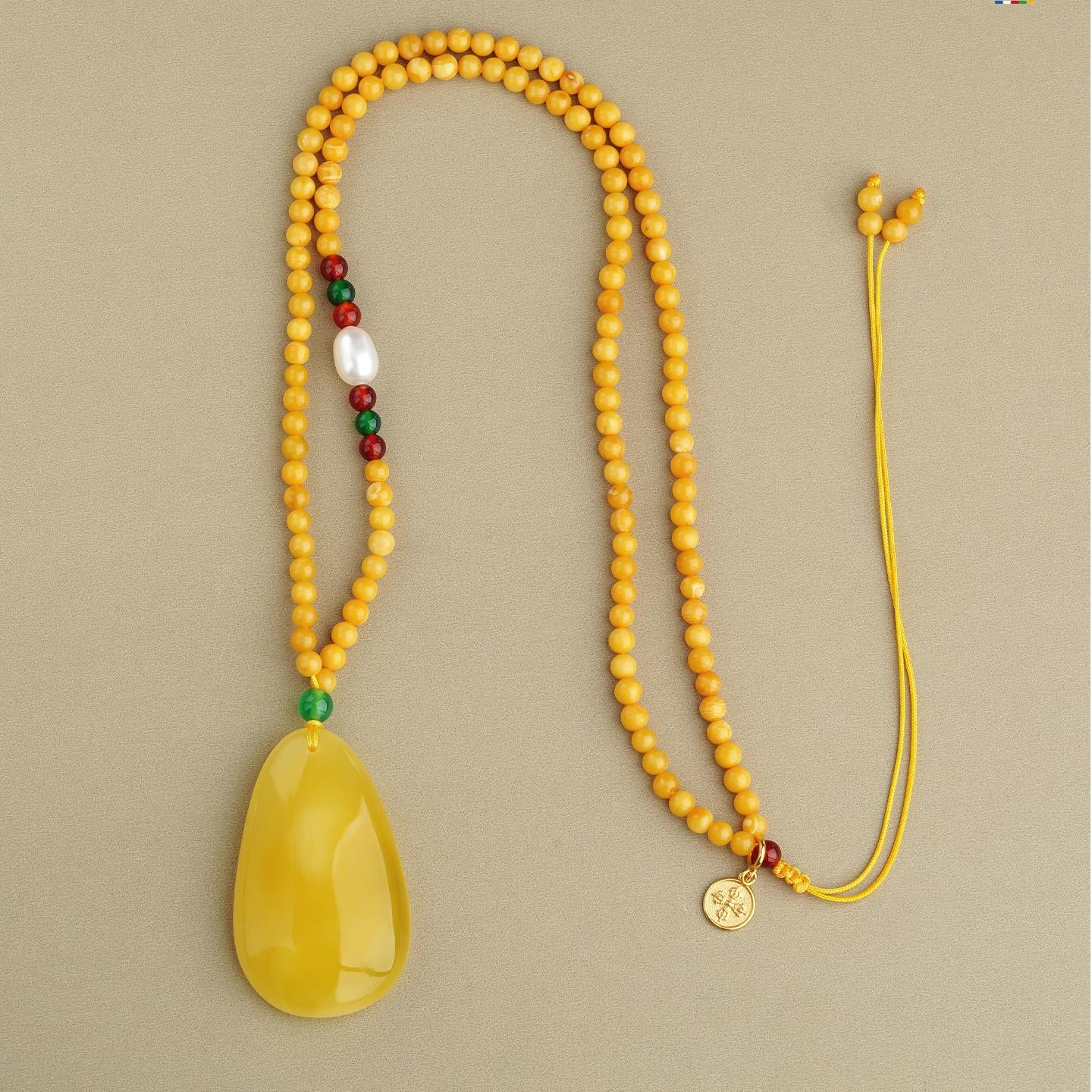 Handmade Tibetan amber jewelry piece combining honey amber, agate, and pearls for calm and wisdom.
