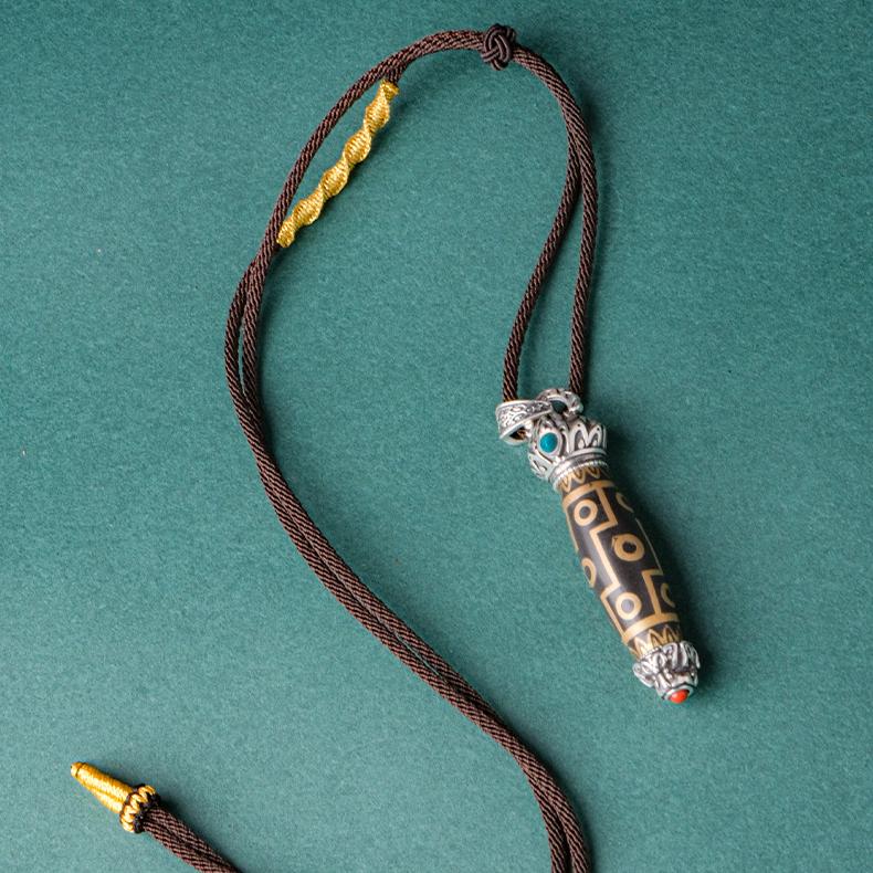 Sacred Tibetan Buddhist Dzi bead pendant with twelve eyes, promoting clarity and strength.