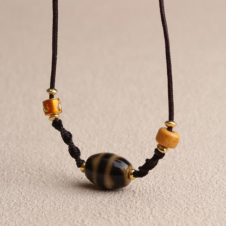 Handmade Tibetan Dzi tiger tooth bone pendant amulet for protection and strength.