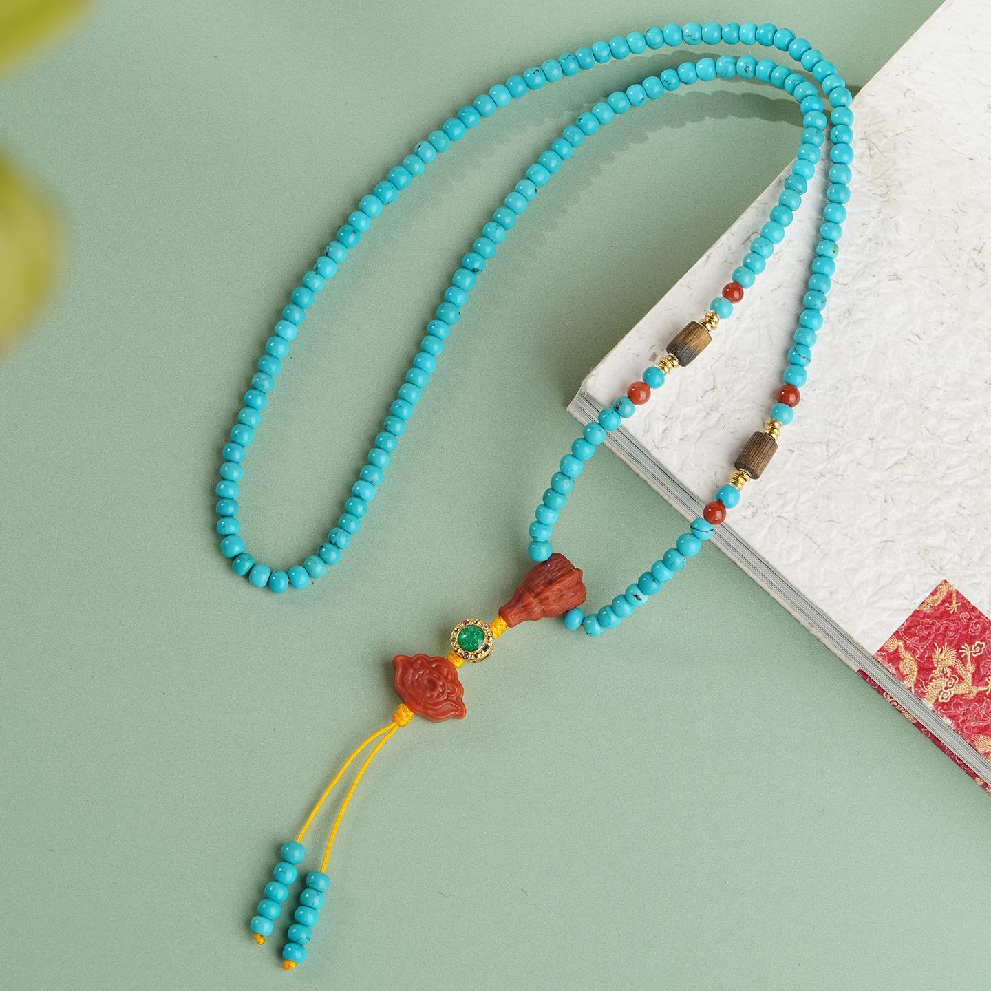 Handcrafted Tibetan necklace with turquoise, red agate, and lotus carving for inner calm and spiritual protection.