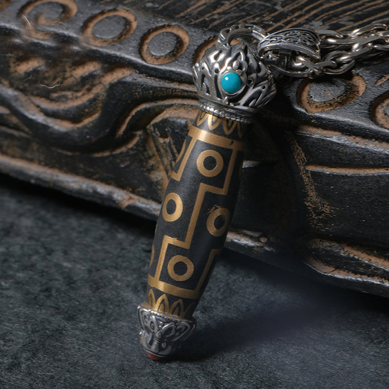 Tibetan Buddhist handcrafted jewelry featuring twelve-eyed Dzi and incense ash in silver.