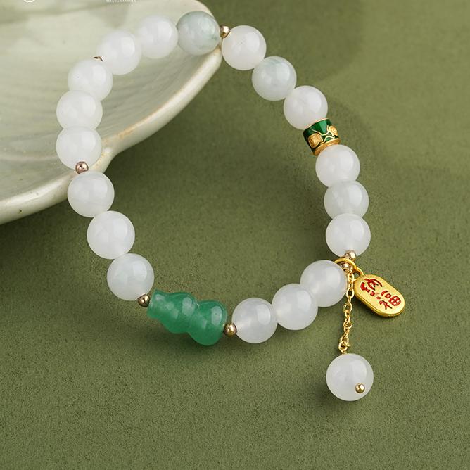 Close-up of Golden Silk Jade Gourd Bracelet Style A in Tibetan Buddhist tradition, featuring meticulously hand-carved gourd pendants symbolizing good fortune and healing. This handmade jewelry art piece combines natural quartzite jade with sacred symbolism