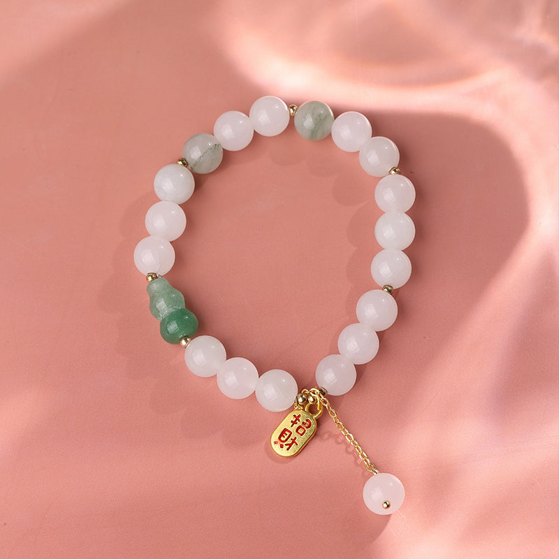 Detailed view of a hand-painted Golden Silk Jade gourd bracelet showcasing intricate Buddhist motifs. Each gourd bead is individually painted, making this spiritual jewelry art a unique protective amulet.