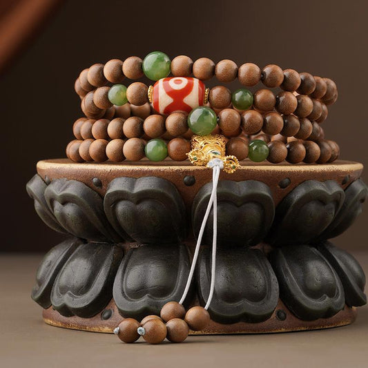 Handmade Tibetan mala necklace crafted from Laosandal wood, green jade, agate Dzi bead, and 925 silver Vajra elements