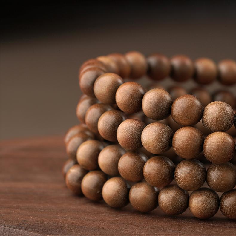 Handcrafted Tibetan-Buddhist prayer beads featuring Laosandal wood, green jade, red agate Dzi bead, and 925 silver details