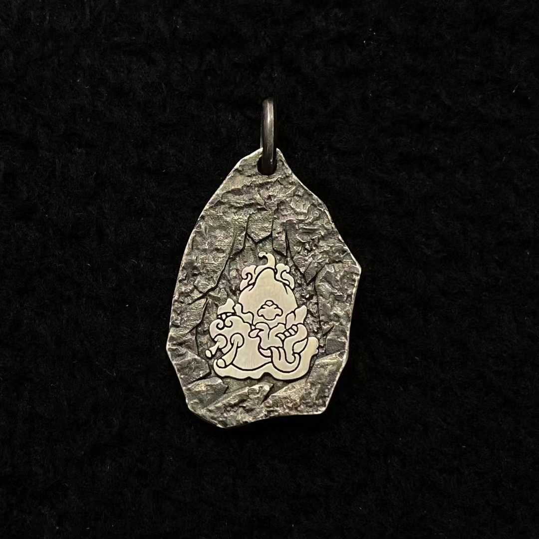 Sacred gold and silver Mahakala protection pendant featuring Tibetan Buddhist artistic details.