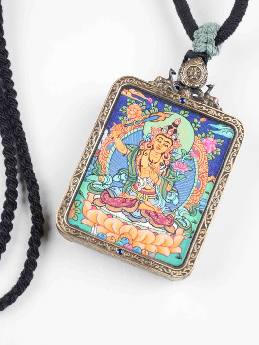 Handcrafted Tibetan thangka hanging of Manjushri, the Bodhisattva of Wisdom, zodiac protector amulet painted with natural mineral pigments.

Small Tibetan thangka pendant of Manjushri, zodiac guardian amulet