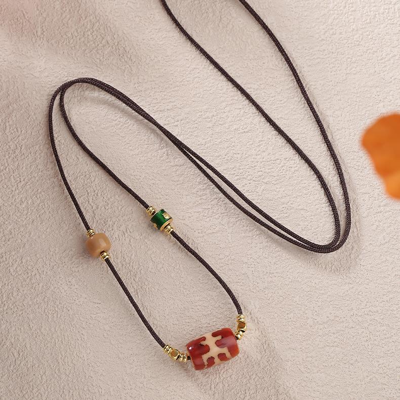 Spiritual amulet necklace featuring a Nobleman Dzi symbol for protection and auspicious connections.