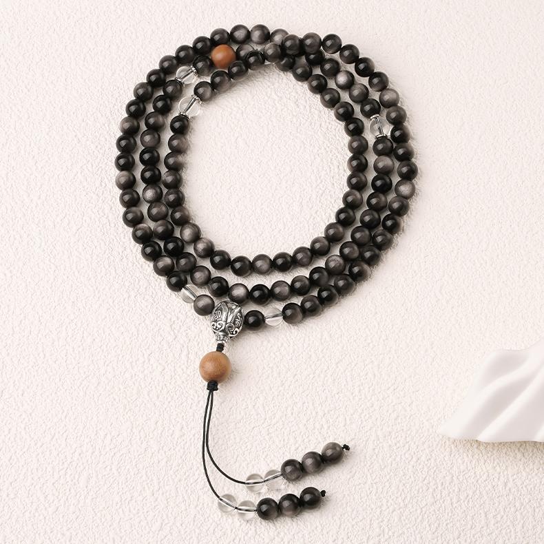 Handmade Tibetan Buddhist obsidian mala featuring sandalwood beads white crystal accents and 925 silver three way connector