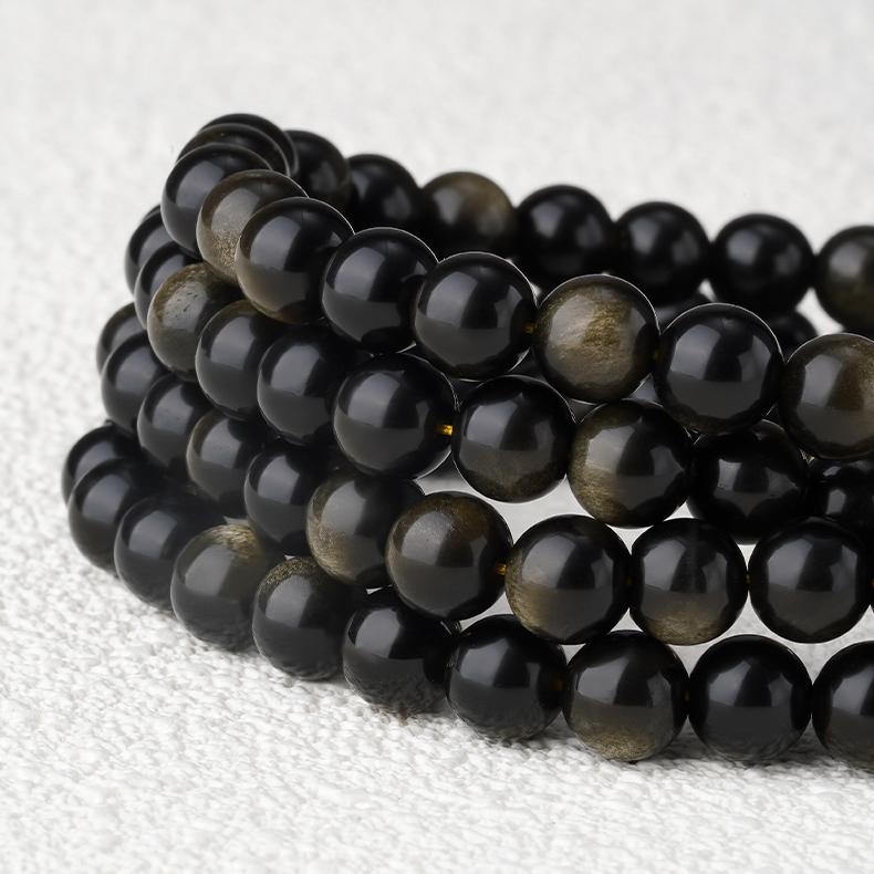 Handcrafted golden obsidian mala with crystal and silver details, traditional Tibetan spiritual jewelry.