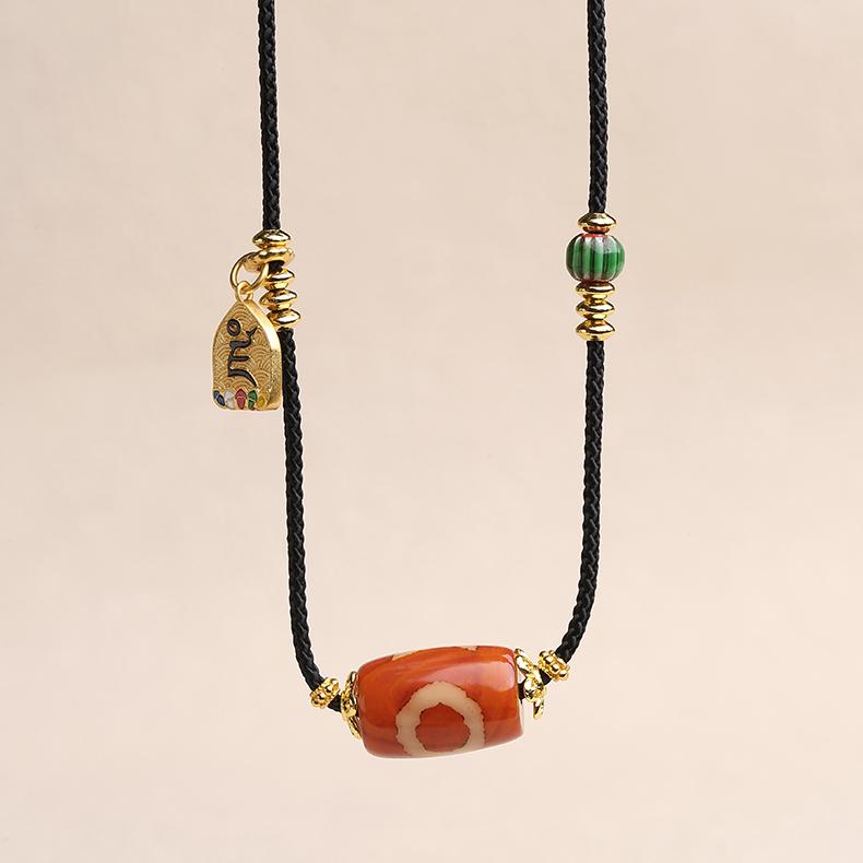 Handcrafted pendant with a red agate bead and a blue glass celestial ornament.