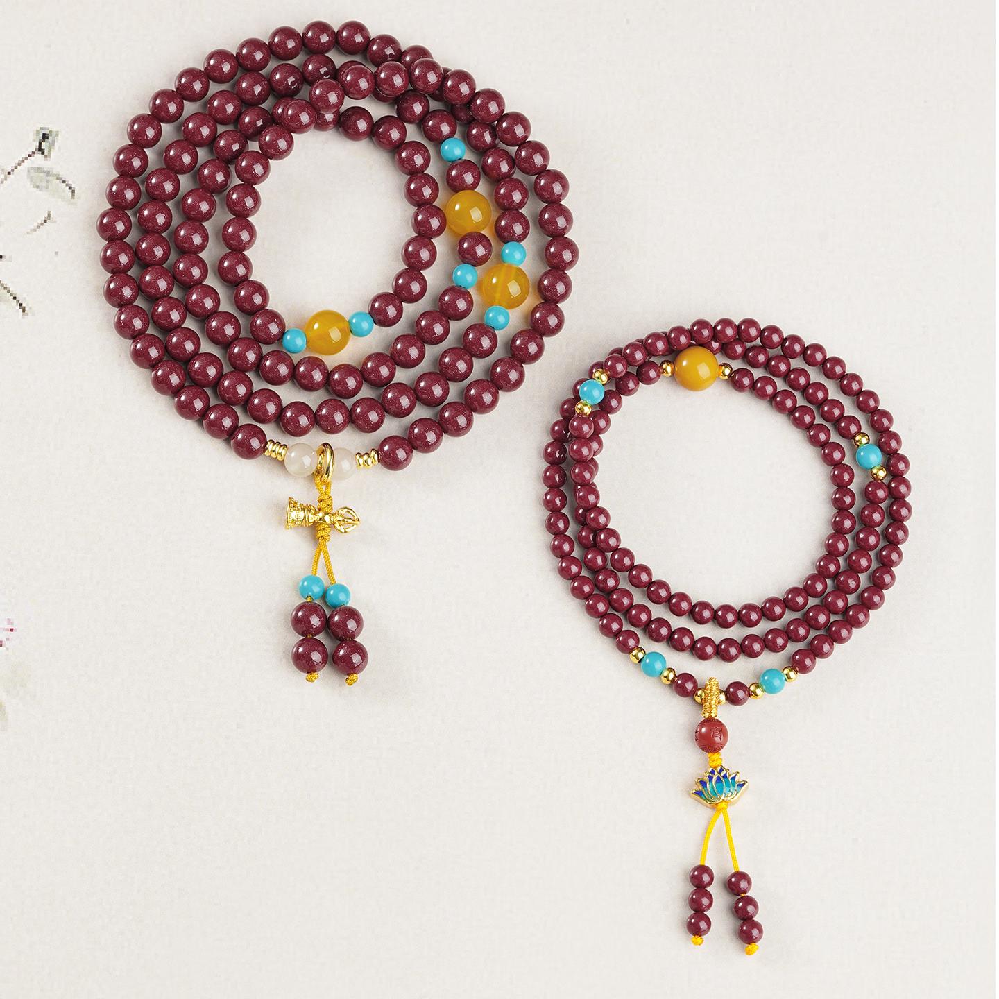 Artisanal cinnabar 108 mala inspired by Tibetan jewelry design with amber and glass details.