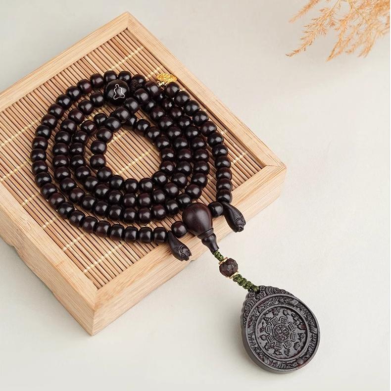 Artisan Tibetan red sandalwood Bagua pendant with gold detailing for energy alignment and wisdom.