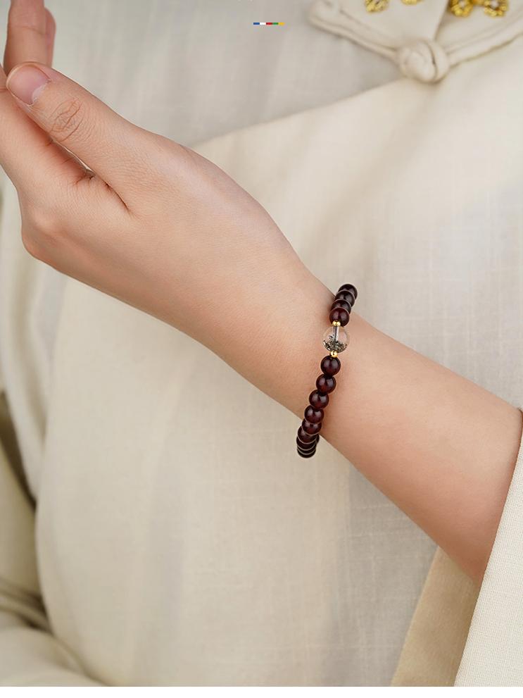 Tibetan-inspired sandalwood bracelet with green phantom crystal and sterling silver decorative beads.