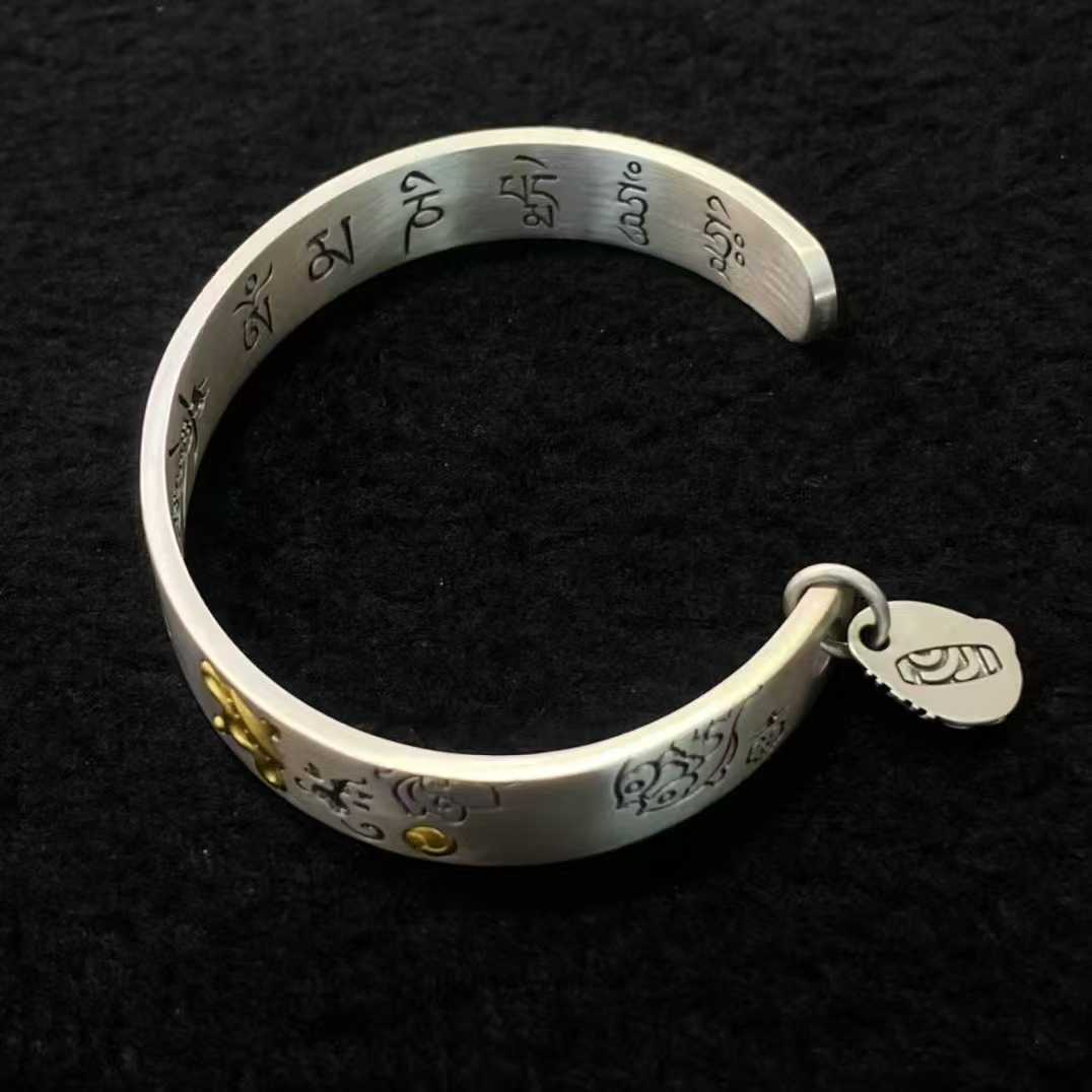 S925 silver handcrafted bracelet showcasing detailed Tibetan Buddhist blessing symbols.