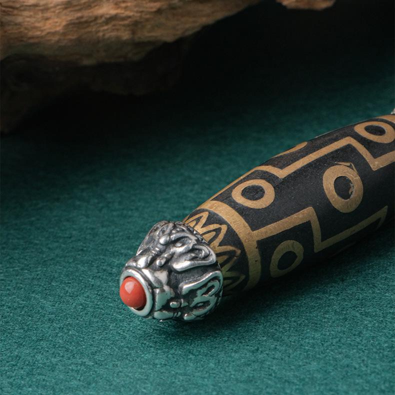 Elegant Dzi bead pendant with sterling silver chain, symbolizing blessings and spiritual power.