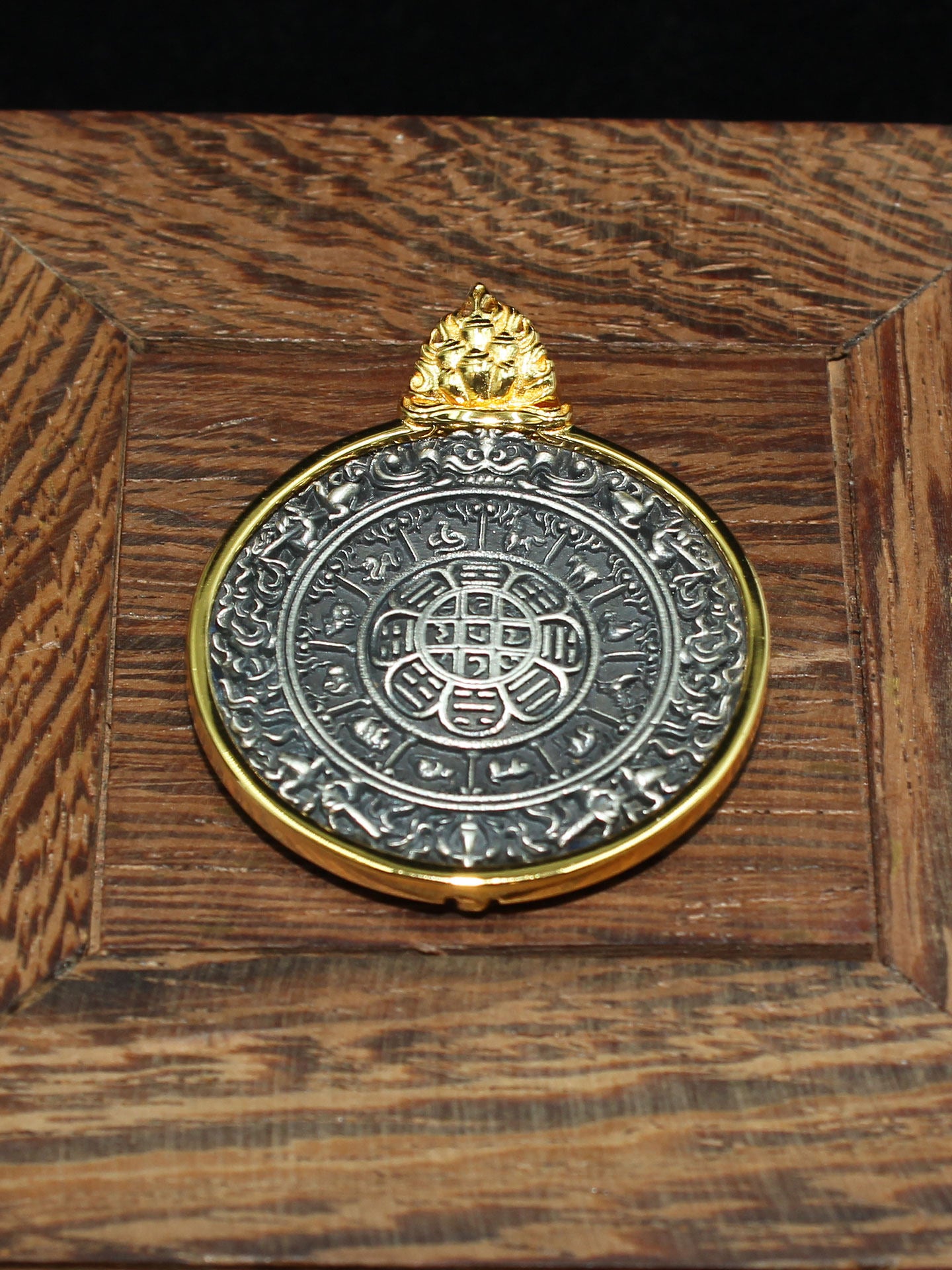 Intricate Buddhist sacrificial items art showing the twelve Chinese zodiac signs and Ba Gua symbols on a silver-gilded astrological mandala.