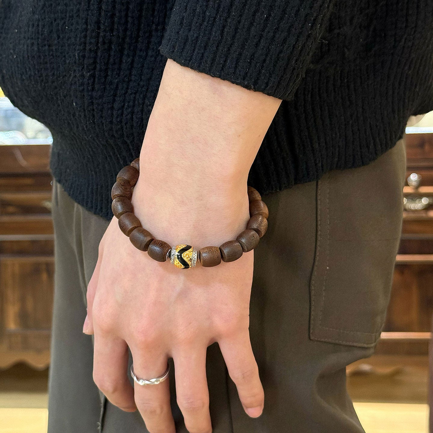 Artisan-crafted 24K gold-plated silver spacers on an agarwood prayer bracelet, inspired by Tibetan Buddhist sacrificial implements culture.
