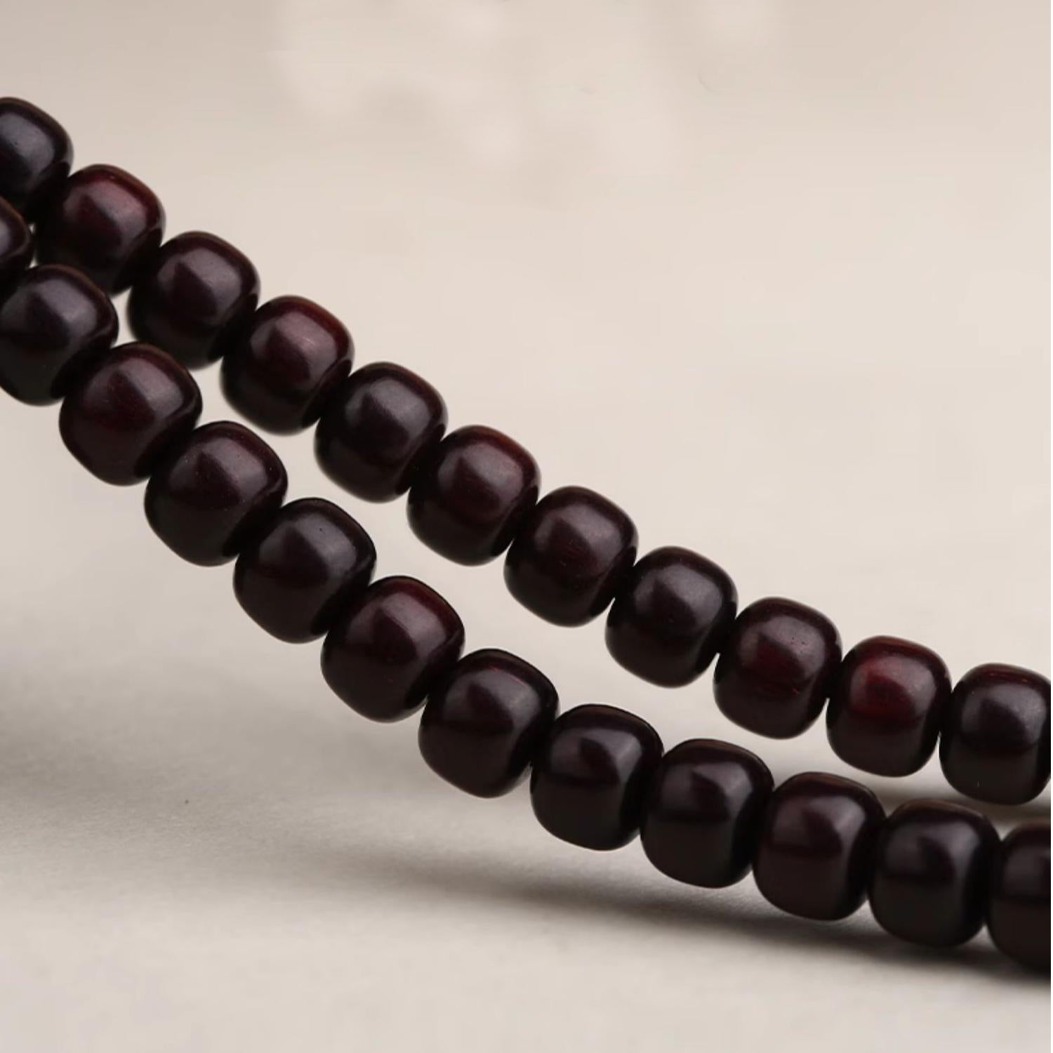 Red sandalwood Eight Trigrams necklace with 18k gold charm for balance, luck, and protection in Tibetan tradition.