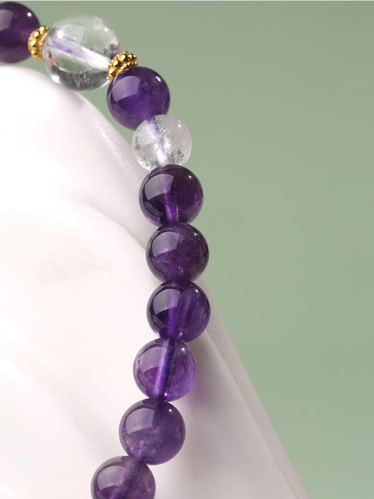 Artisanal Amethyst and Clear Quartz beaded bracelet featuring bronze accents and adjustable cord in Tibetan-Buddhist style.