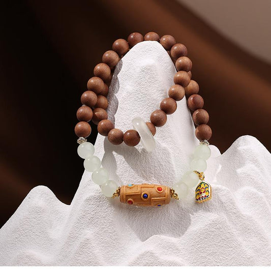 Handcrafted Tibetan-Buddhist sandalwood bracelet featuring a Nine-Eye Dzi carving and glass round beads for meditation and peace