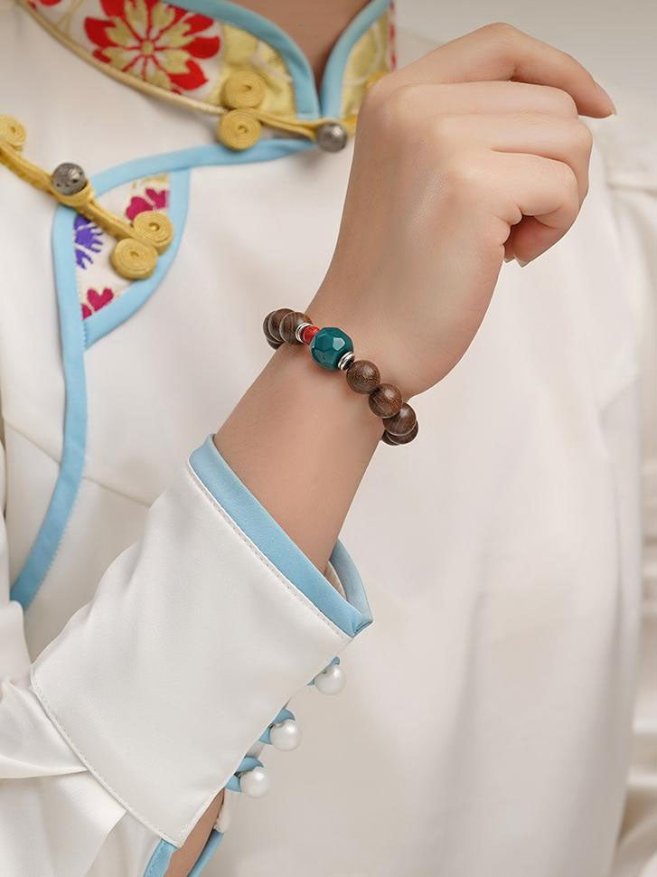 Spiritual Tibetan Buddhist bracelet featuring golden nanmu beads and thangka painting influences, offering protection and blessings.