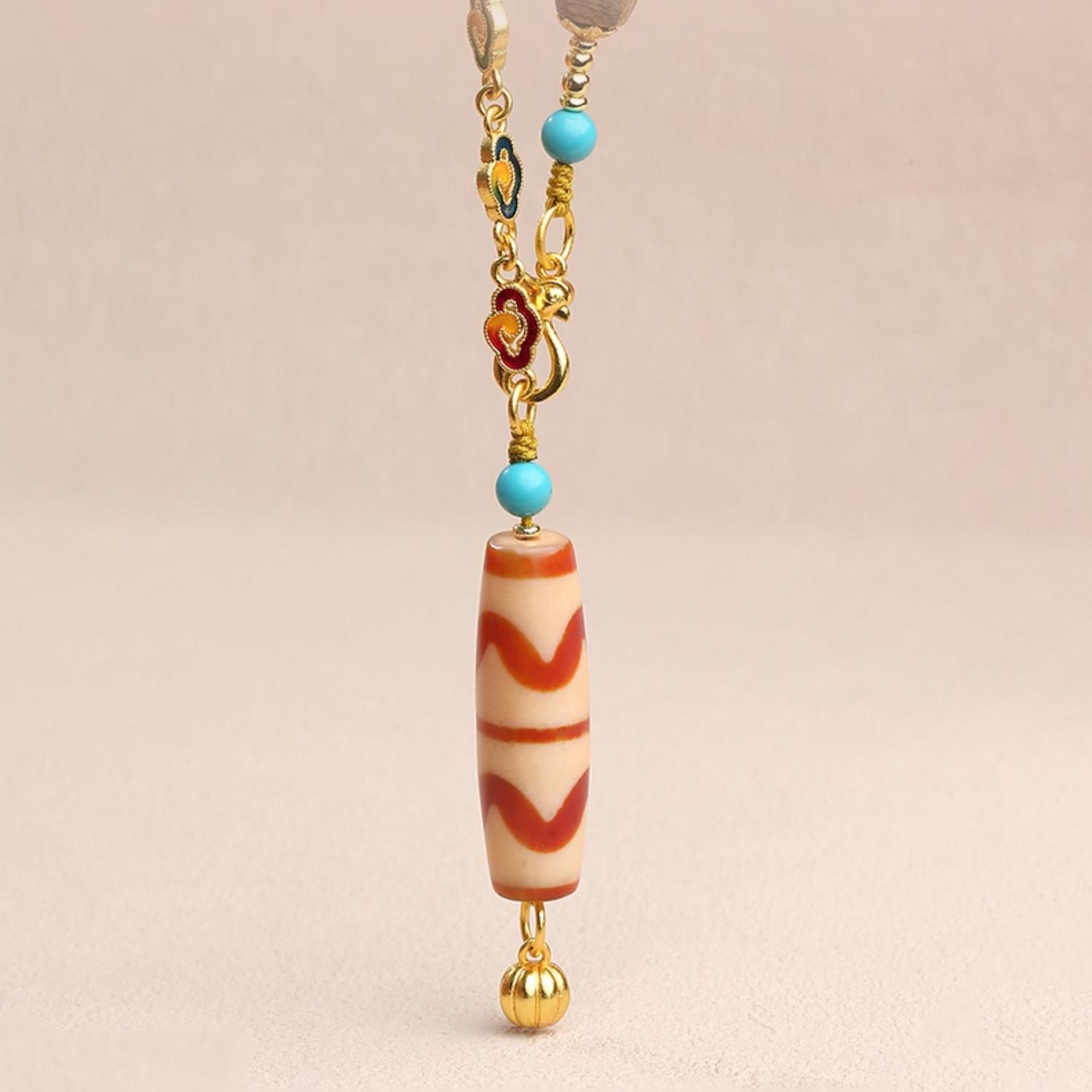 Handmade brass cloud amulet with Dzi bead pendant for spiritual protection.
