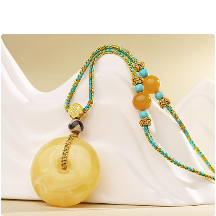 Tibetan Buddhist artisan pendant featuring amber Ping An knot and tiger tooth Dzi bead