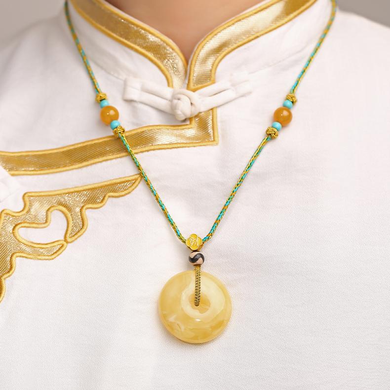 Handmade Tibetan Buddhist pendant with amber Ping An knot and tiger tooth Dzi bead, symbolizing peace and vitality