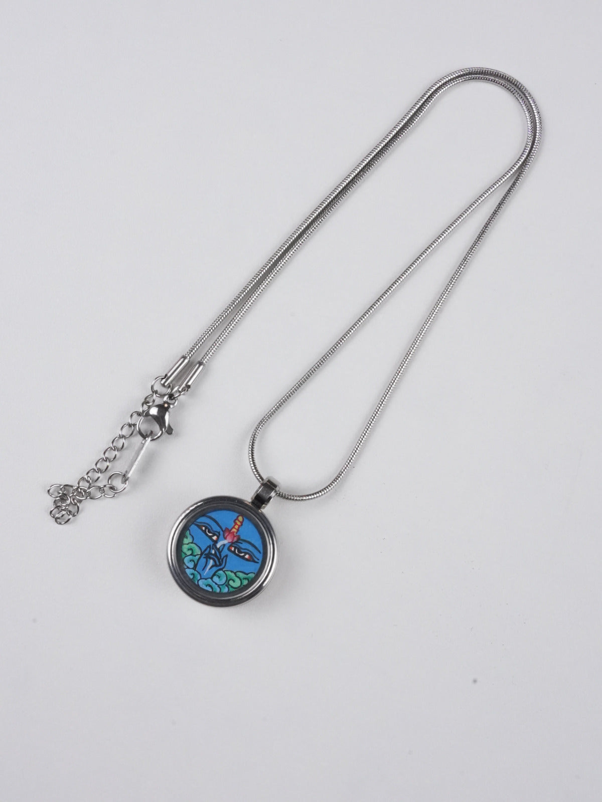 Traditional Tibetan Buddhist Vajrapani protection necklace, miniature thangka pendant hand-painted on sacred canvas, symbolizing divine energy in Buddha art.