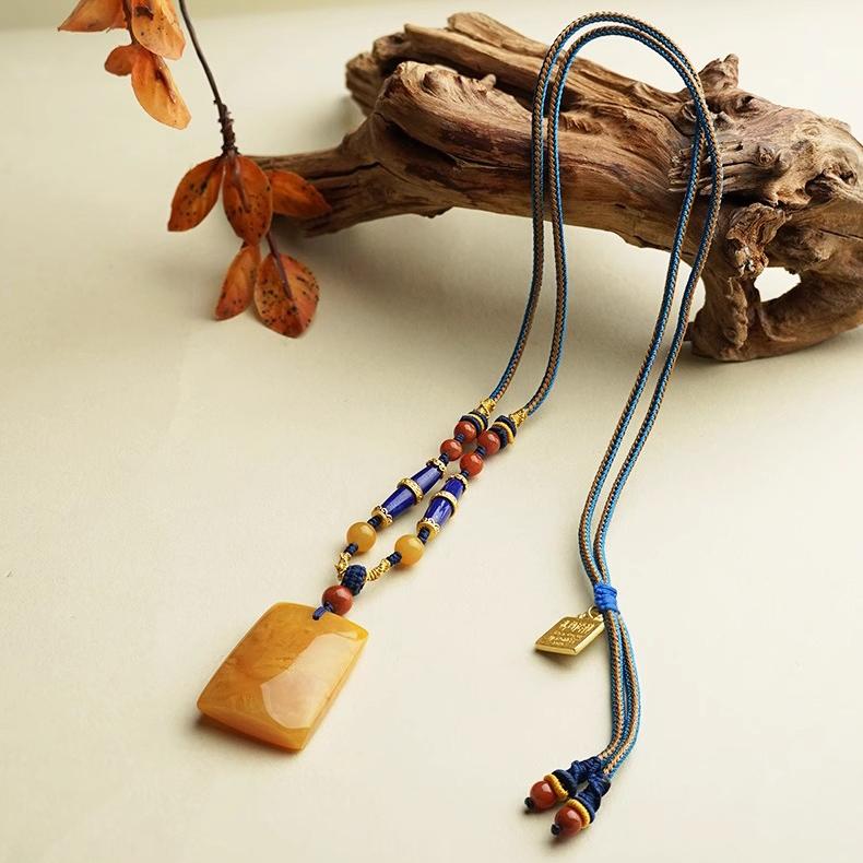 Healing Tibetan Buddhist amber pendant, handcrafted with lapis lazuli.