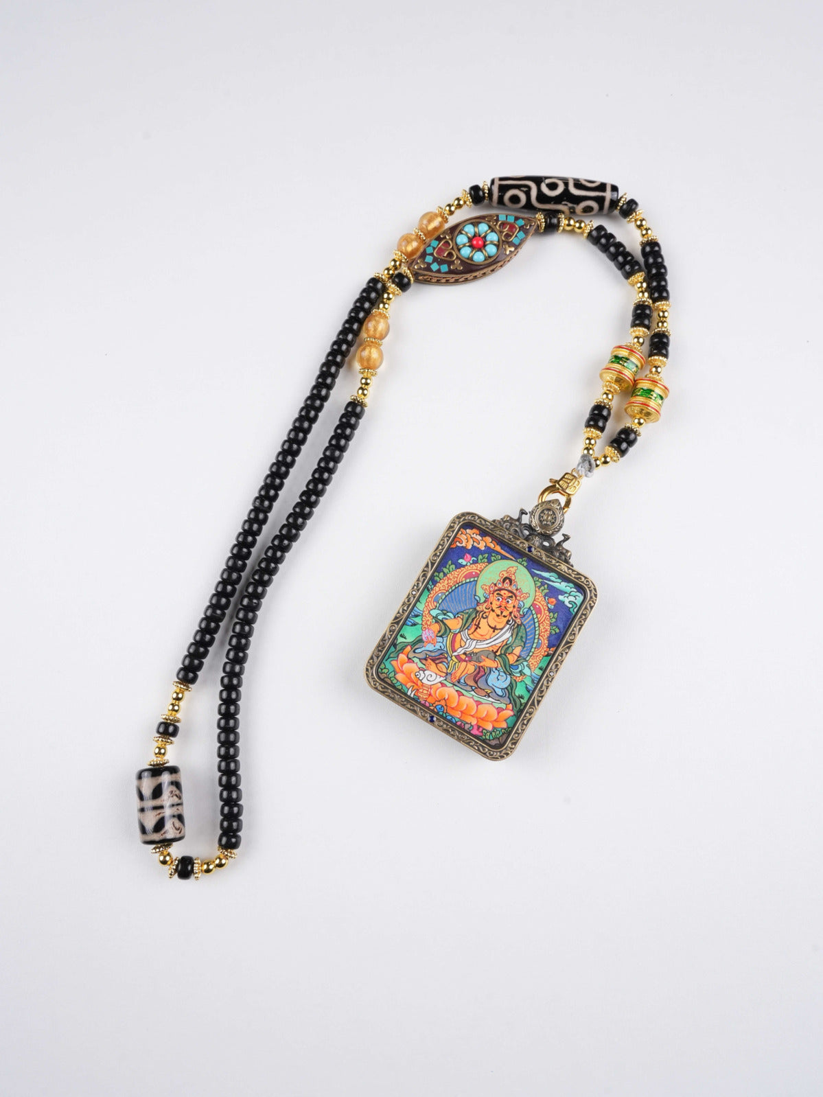 Handcrafted Tibetan thangka pendant of Jambhala, the Buddhist Wealth Deity bringing fortune and harmony.