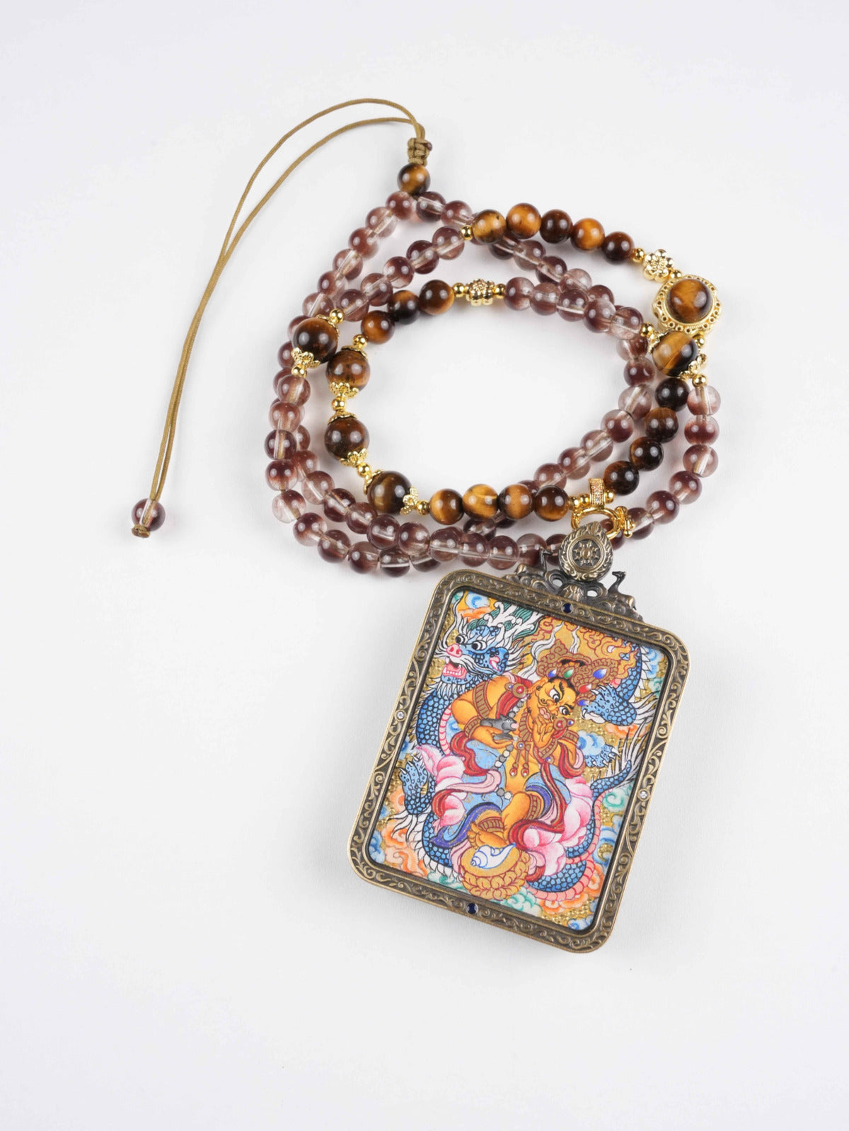 Vibrant Yellow Jambhala thangka pendant painted with natural mineral pigments on authentic thangka cloth.

