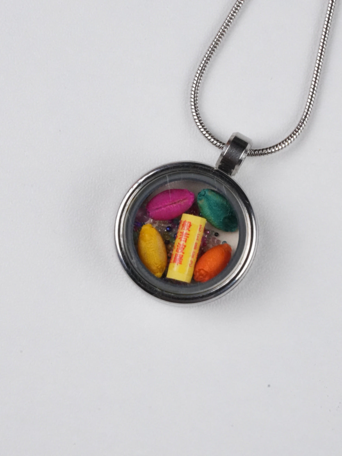 Unique tibetan-buddhist candy pendant jewelry, hand-painted with mineral pigments on thangka cloth, blending traditional Buddha art with joyful color expression.