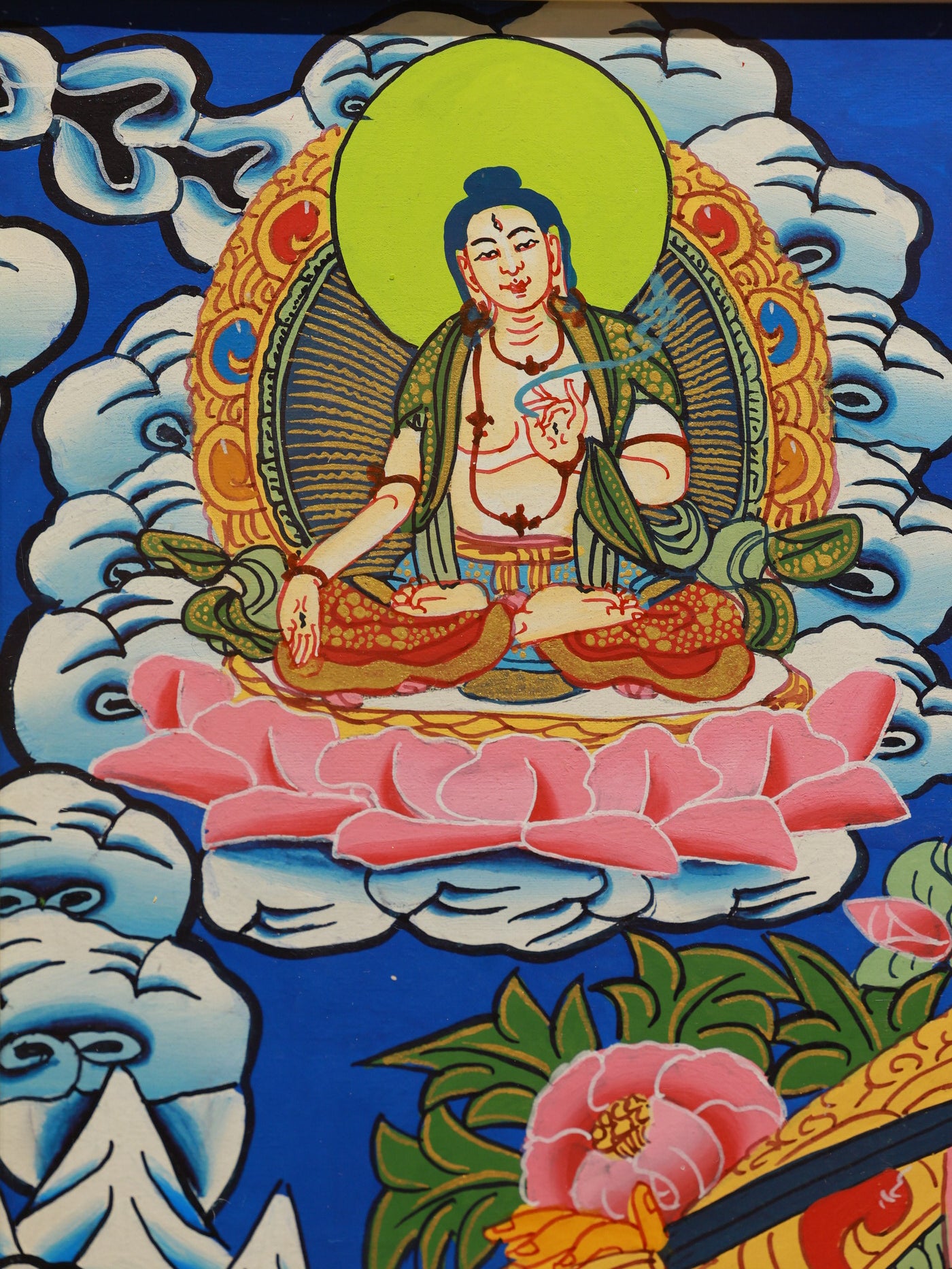 Vibrant Tibetan color thangka of Manjushri, featuring sacred symbols such as the Dharma wheel, lotus, and Tibetan script.
